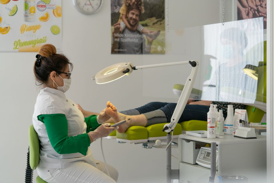A podiatrist examines a patient's foot during a clinical visit, highlighting diabetic foot care.